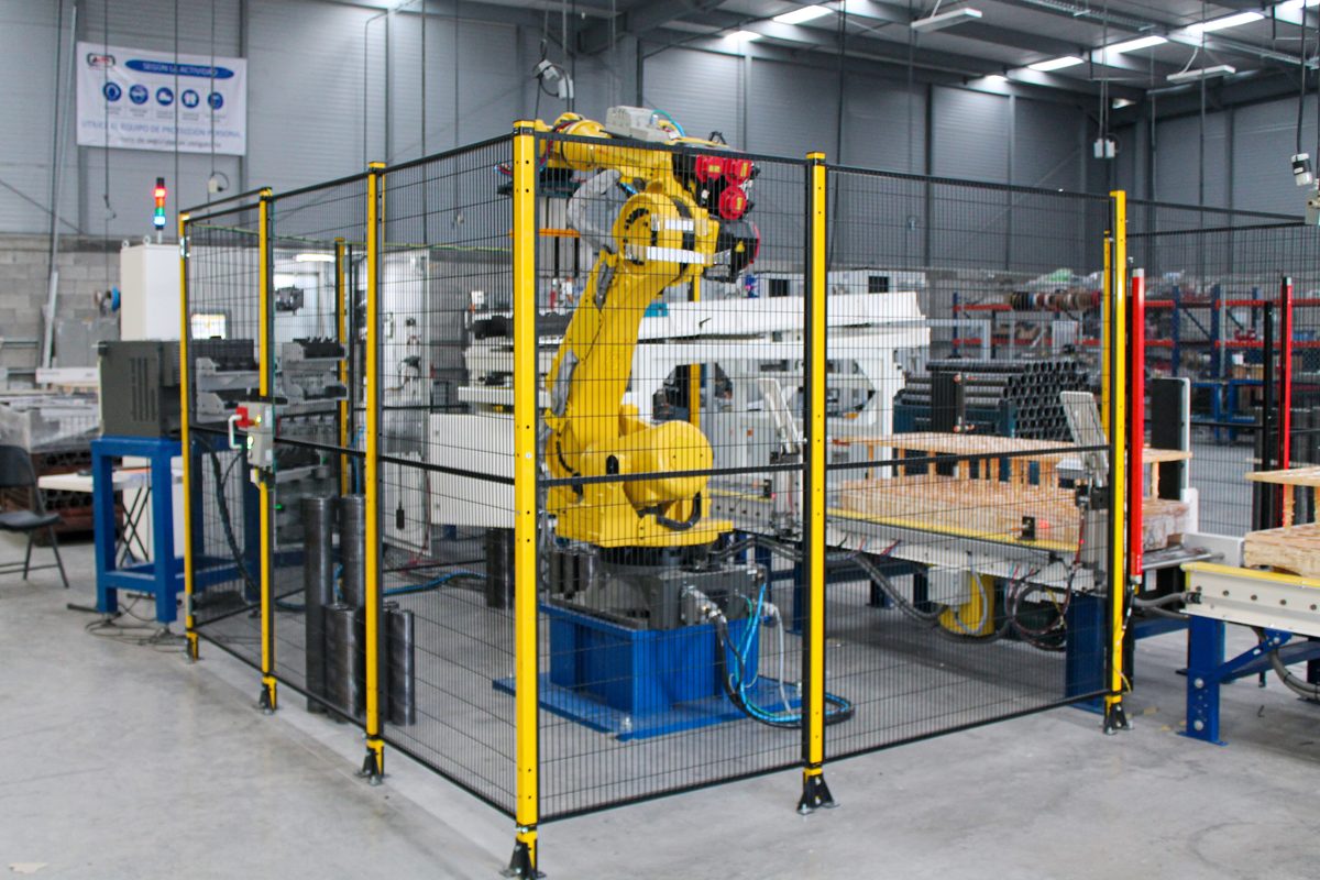 FANUC robotic cell with safety fencing for automated material handling at AMD Machines facility
